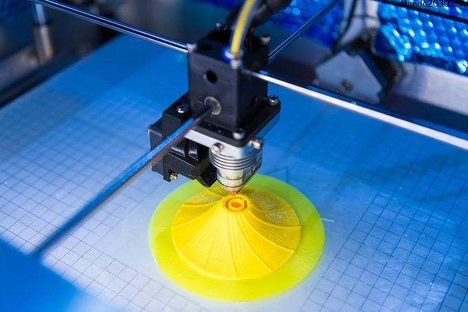 Máquina de impresión 3D que imprime una forma de remolino amarillo