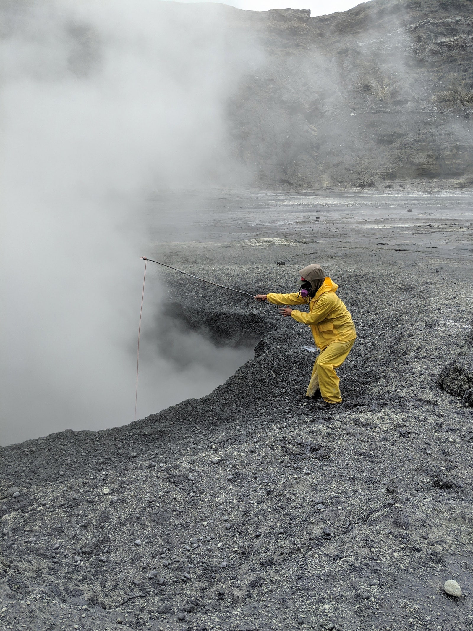 un explorador sumerge algo en un volcán