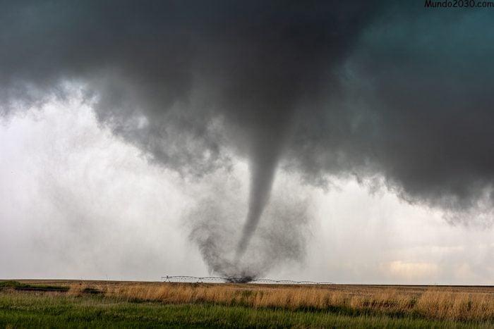 Un tornado gira en un campo debajo de una tormenta supercélula durante un evento meteorológico severo en Selden, Kansas.