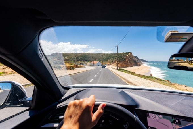 Perspectiva personal punto de vista de un hombre que conduce a lo largo de la costa atlántica en Portugal