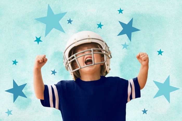 Niño con casco de fútbol americano animando con los puños cerrados